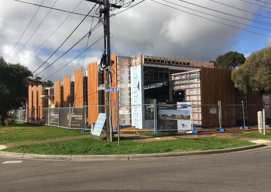 a building under construction with a fence and grass