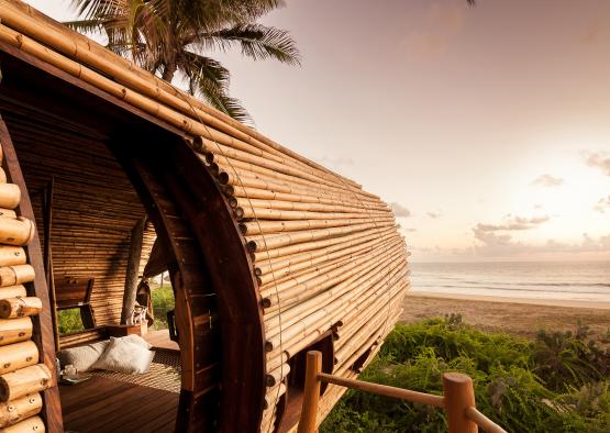 a wooden structure with a beach and ocean in the background