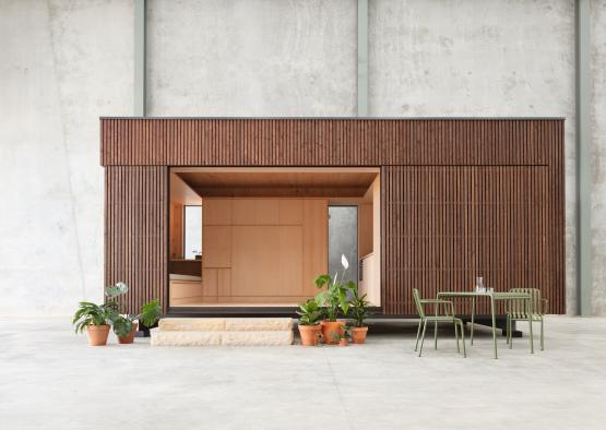 a wooden building with a table and chairs