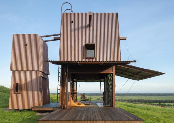 a wooden structure in a grassy field