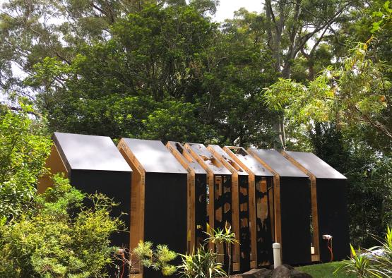 a group of black shed in a forest