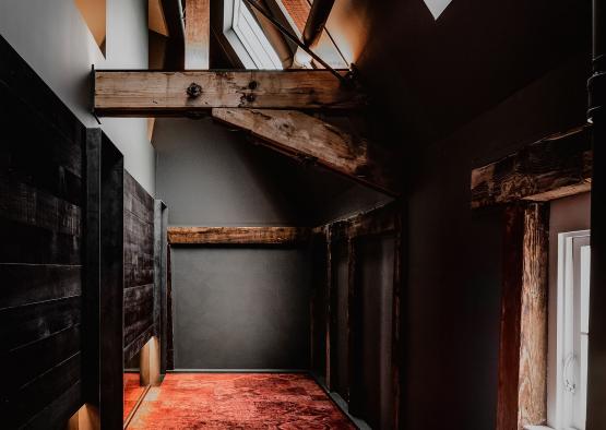 a hallway with a red carpet and wooden beams