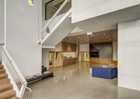 a large room with a staircase and a blue couch