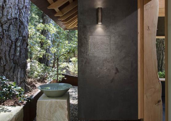 a stone sink in a room with a wood roof