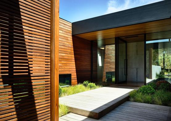 a wooden building with a walkway and a glass door