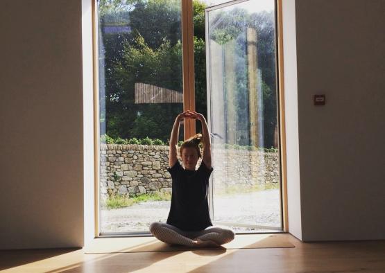 a person sitting on the floor with their hands up in the air