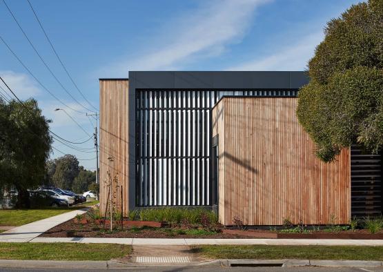 a building with a wood paneled wall and a tree