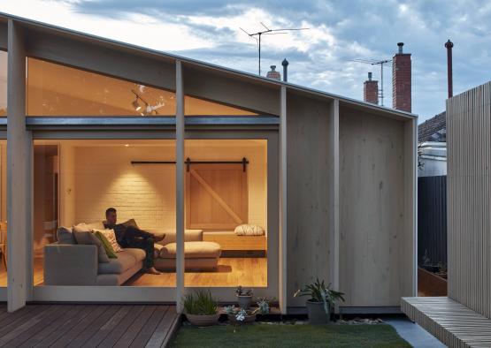 a man sitting on a couch outside of a house