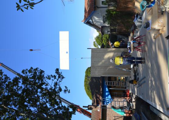 a man standing on a concrete surface with a crane lifting a sign