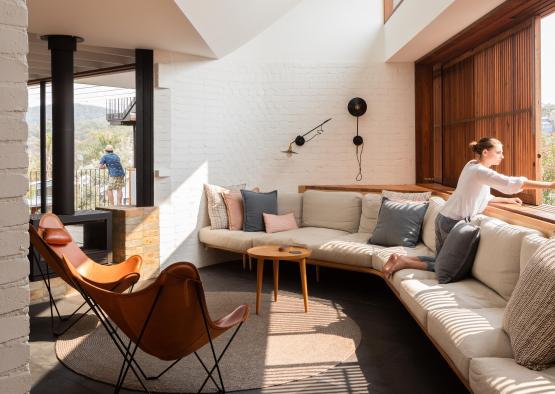 a woman sitting on a couch in a room with a window