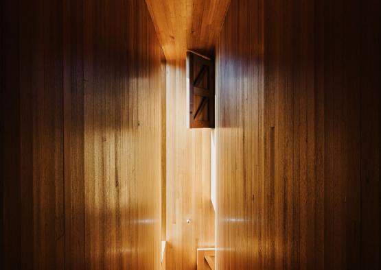 a person standing in a room with a light coming through the walls