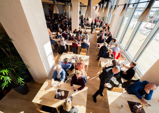 a group of people sitting at tables in a restaurant