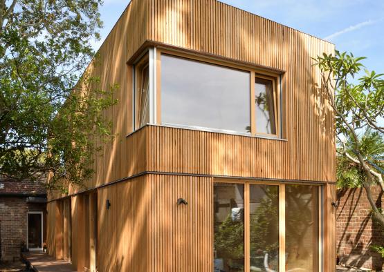 a wooden house with trees in the background