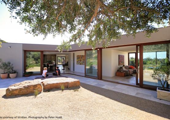 a house with glass walls and a large patio