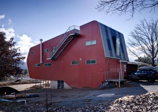 a red building with stairs and a car parked in front of it