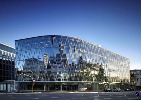 a glass building with a curved roof with Sprint Center in the background