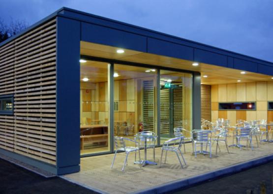 a building with a glass wall and tables and chairs