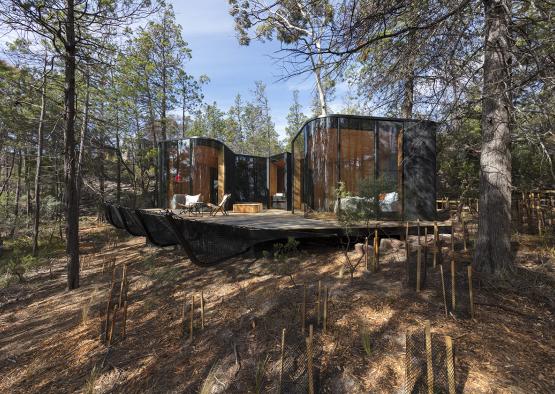 a house with a deck in the woods