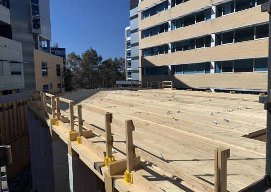 a wooden deck with railings and a building in the background