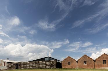 a building with a brick wall and a brick building in the background