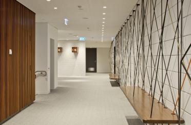 a hallway with a wooden shelf and a white wall