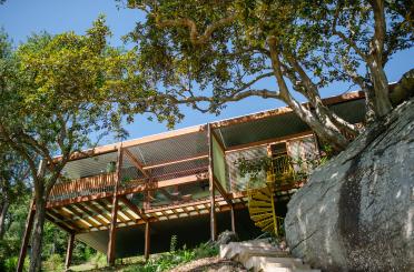 a building with a large rock and trees