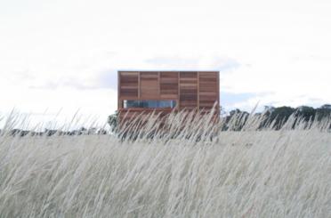 a building in a field of tall grass