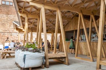 a wooden structure with people standing around